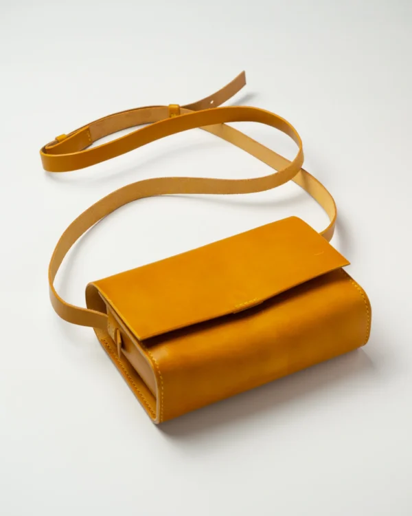 torebka-nr1-habaz-musztardowa-produktowe-całość-zamknięta Skórzana torebka musztardowa Habaż (Model 1) z paskiem na ramię na białym tle.