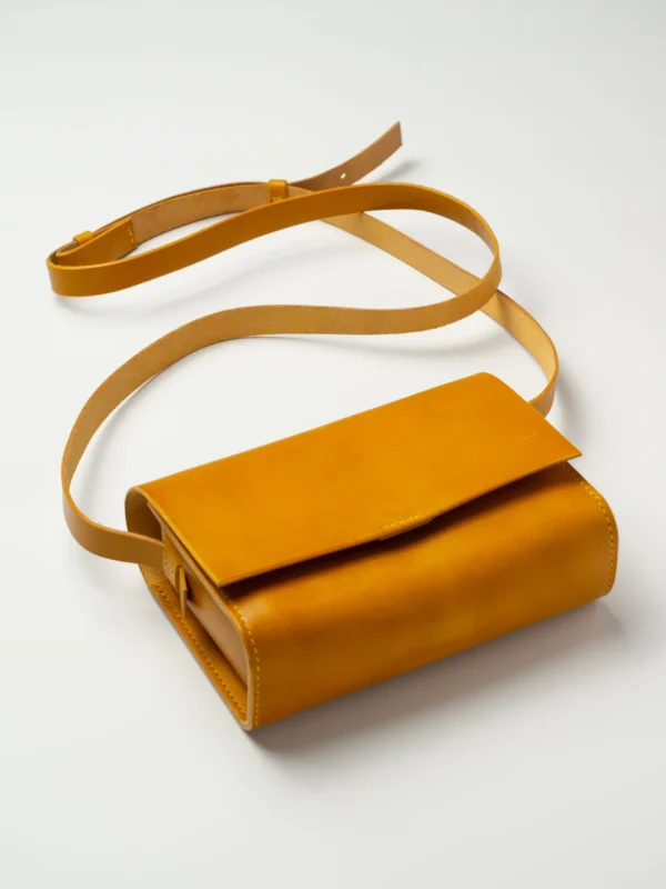 torebka-nr1-habaz-musztardowa-produktowe-całość-zamknięta Skórzana torebka musztardowa Habaż (Model 1) z paskiem na ramię na białym tle.