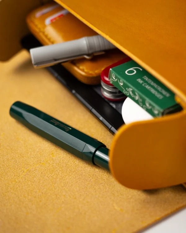 torebka-nr1-habaz-musztardowa-zbliżenie-wnętrza-pióro Zbliżenie na wnętrze musztardowej torby Habaż z zielonym piórem wiecznym i wkładami.