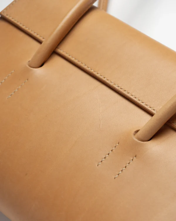 torebka-nr2-habaz-naturalna-detal-szwy-skóra Zbliżenie na szwy i naturalne lico skóry torebki Habaż w kolorze beżowym.