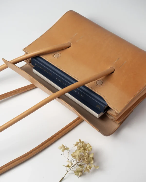 torebka-nr2-habaz-naturalna-edc-wlozone-notesy Wnętrze naturalnej torebki Habaż z widocznymi włożonymi notesami i suszonym kwiatem.