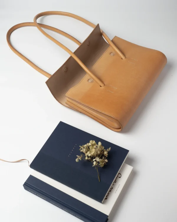 torebka-nr2-habaz-naturalna-produktowe-ksiazki-kwiat Naturalna torebka Habaż na białym tle, obok notesy i suszony kwiatek.