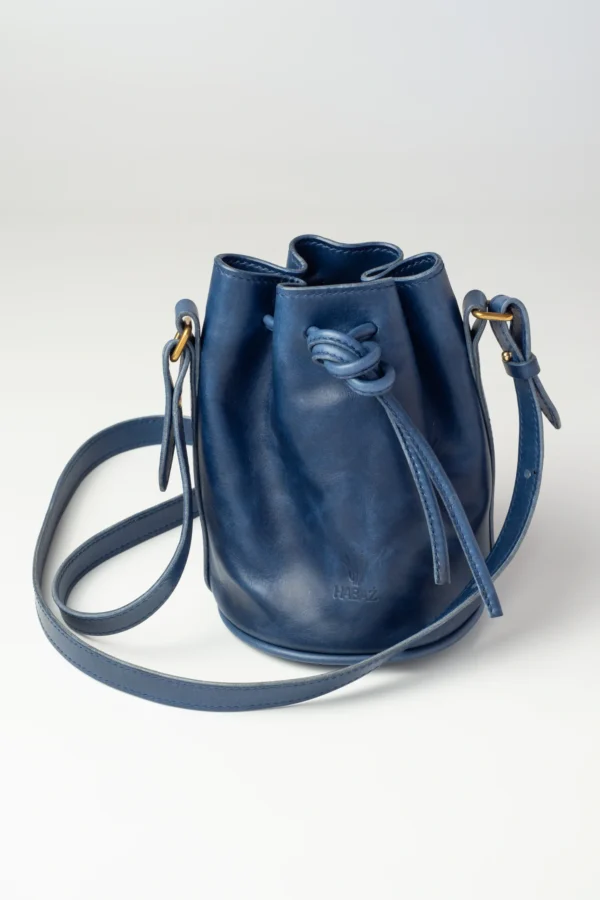 torebka-nr3-habaz-chabrowa-produktowe-całość-z-zawiązaniem Skórzana torebka-worek Habaż w kolorze chabrowym z zawiązanym sznurkiem na ramię.