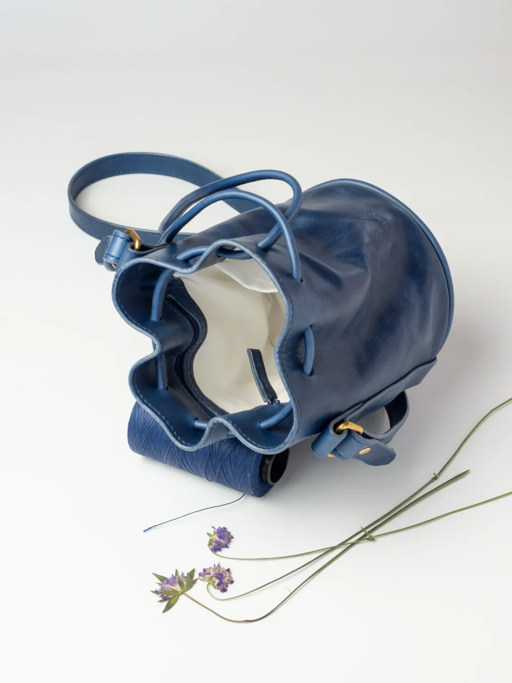 Otwarta chabrowa torebka-worek Habaż z nicią i suszonymi kwiatami.