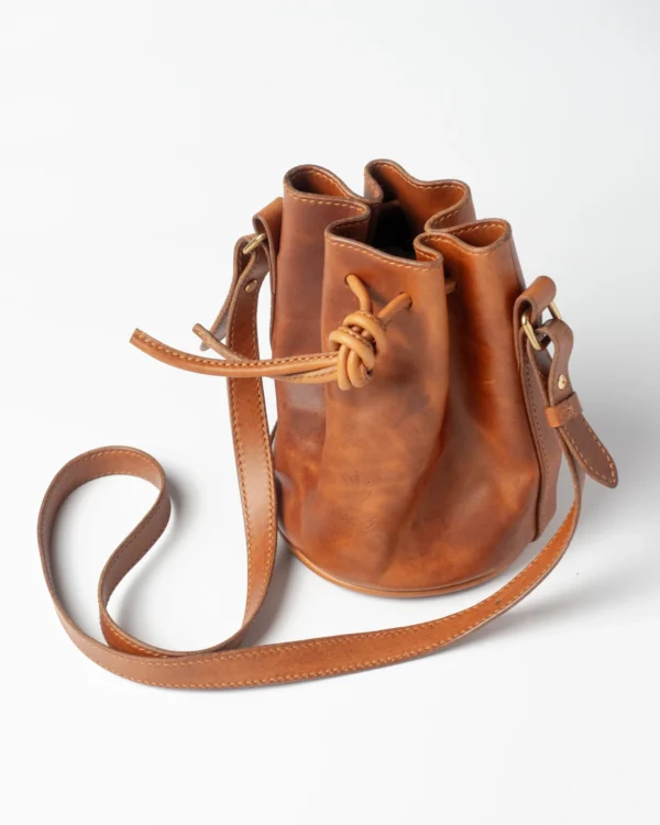 torebka-nr3-habaz-karmelowa-produktowe-całość-zamknięta Skórzana torebka-worek Habaż w kolorze karmelowym z zawiązanym sznurkiem.