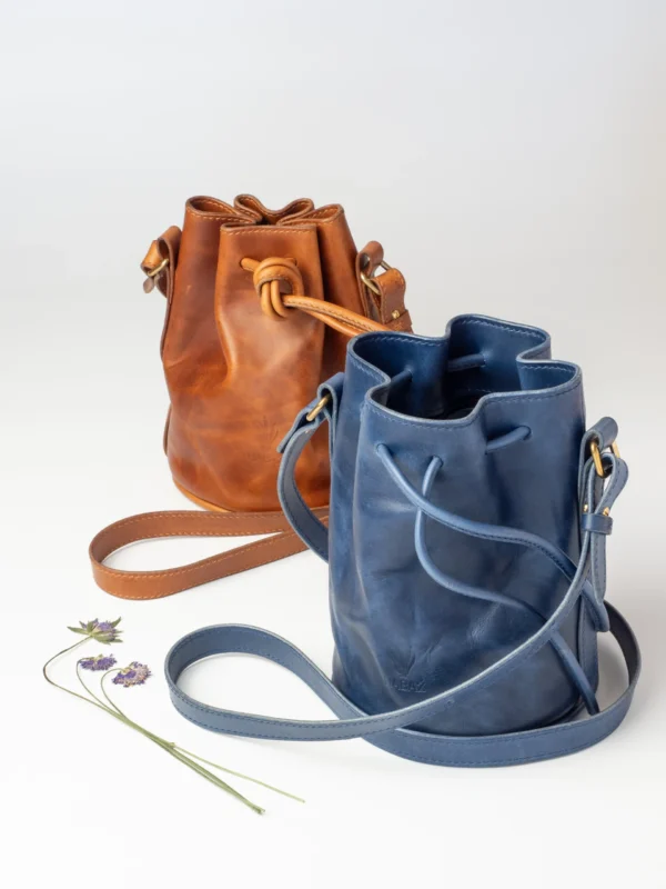 Dwie torebki-worki Habaż (nr 3) w kolorze karmelowym i chabrowym stojące obok siebie.