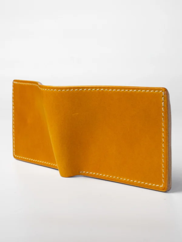 portfel-habaz-musztardowy-całość-otwarty Cały, rozłożony, musztardowy portfel Habaź na białym tle. Ujęcie z boku, ukazujące jego płaską konstrukcję i proste, beżowe szycie.